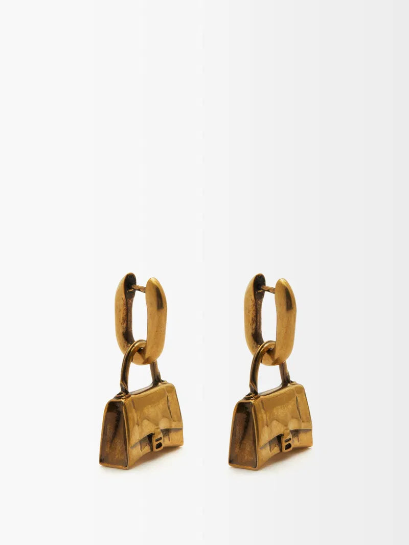 Balenciaga Hourglass Bag Stud Earrings, stylish accessories with gold-tone design and distinctive hourglass shape, on a white background.