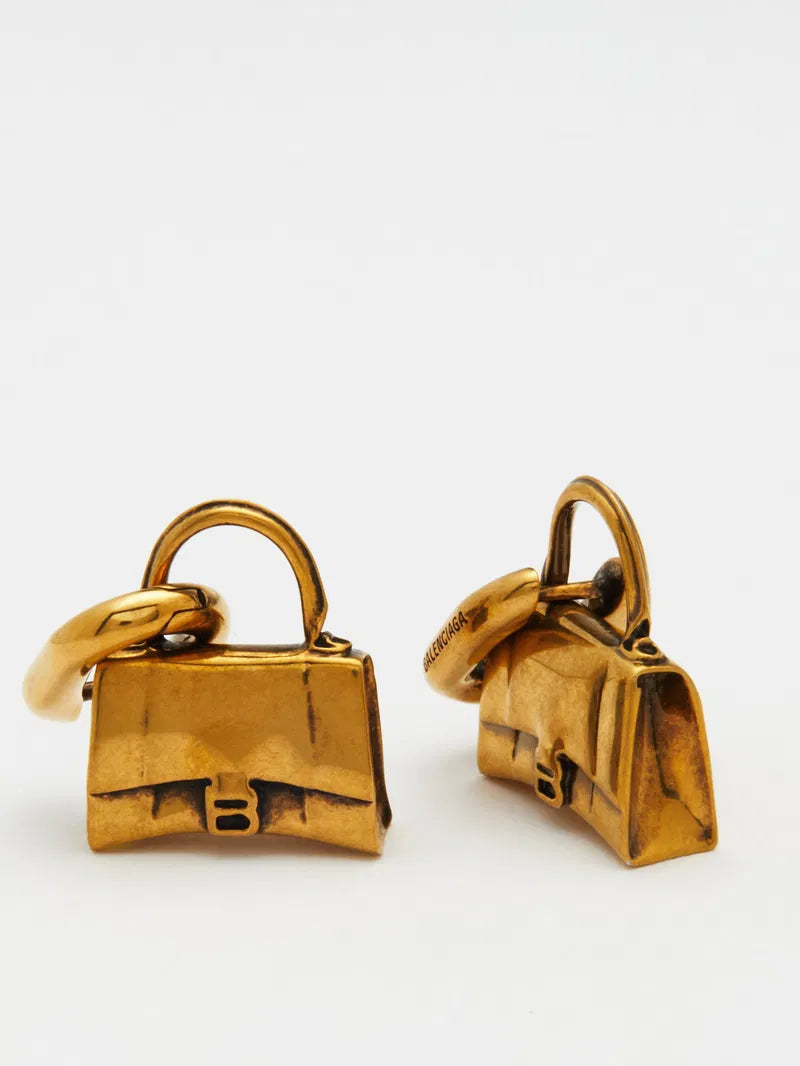 Balenciaga Hourglass Bag Stud Earrings in gold-tone metal with a sleek, modern design, displayed against a neutral background.