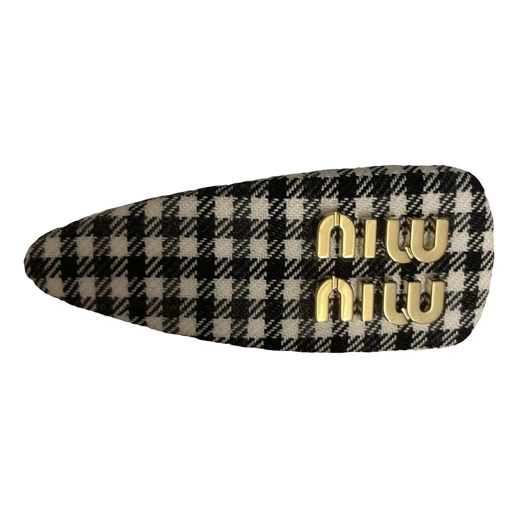 Miu Miu houndstooth hair clip in black and white, stylish accessory for women, featuring a classic pattern and elegant design.