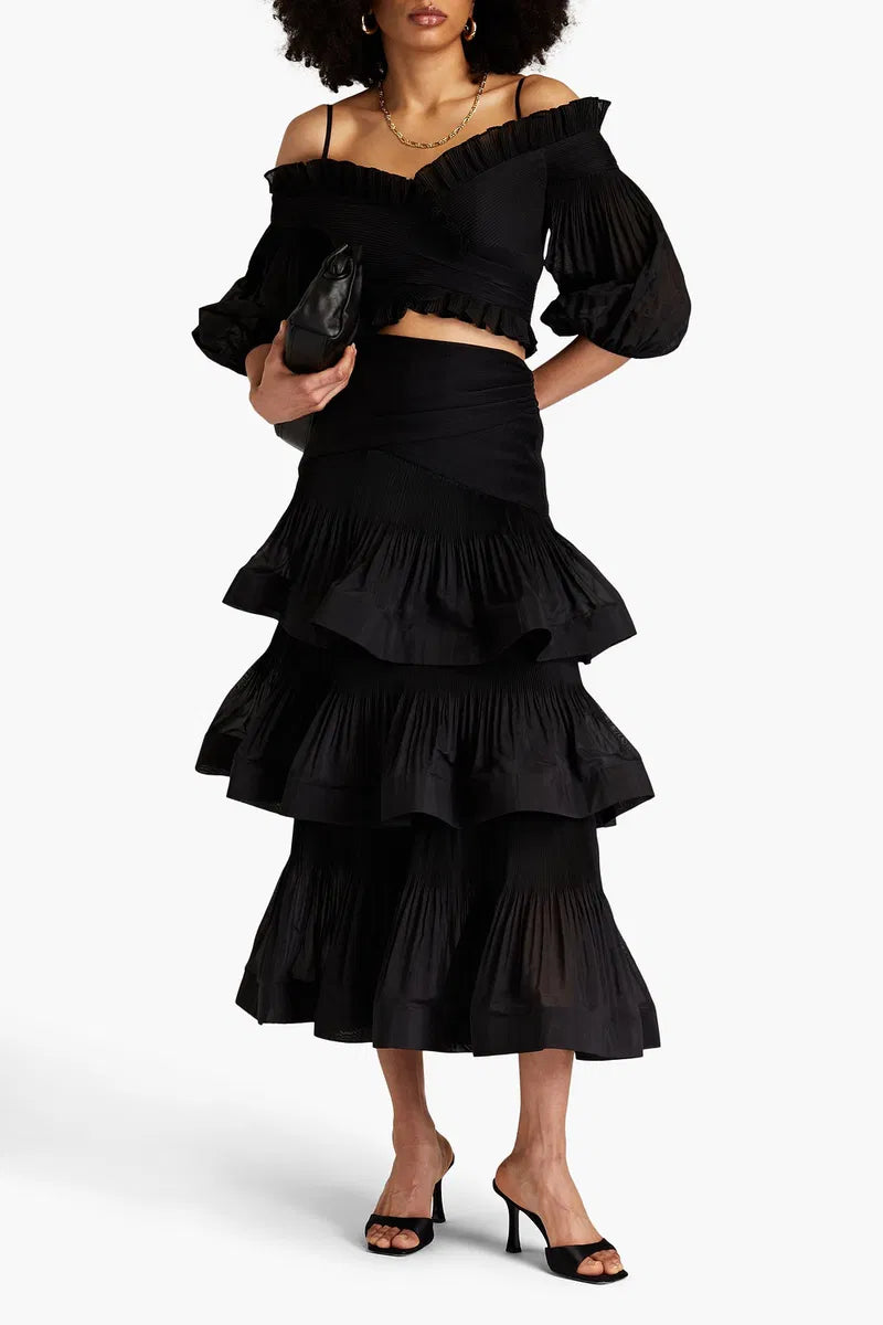 Zimmermann pleated off-the-shoulder top and ruffle skirt set in tiered plissé organza fabric, worn as a stylish women's apparel ensemble.